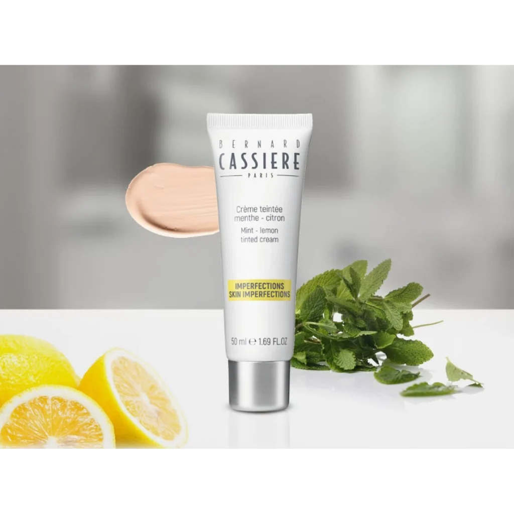 Bernard Cassiere Paris Tinted Cream 50ml tube, displayed with a beige cream swatch, fresh mint leaves, and sliced lemons on a white surface against a soft gray background.