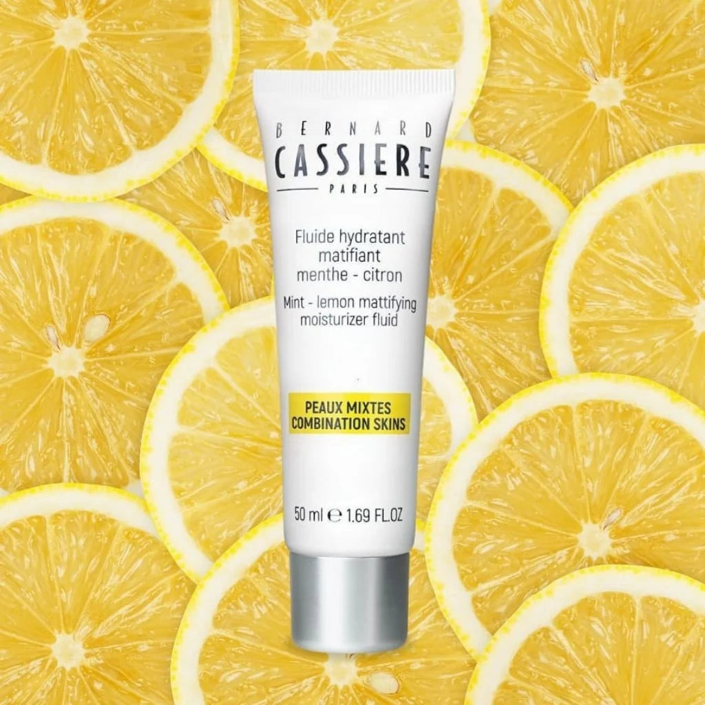 Bernard Cassiere Paris Mint Lemon Mattifying Moisturizer Fluid in a white squeeze tube with a silver cap, set against a background of sliced yellow lemons.