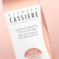 Close up of Bernard Cassiere New skin essence anti-ageing serum booster with light pink/copper background matching serum bottle