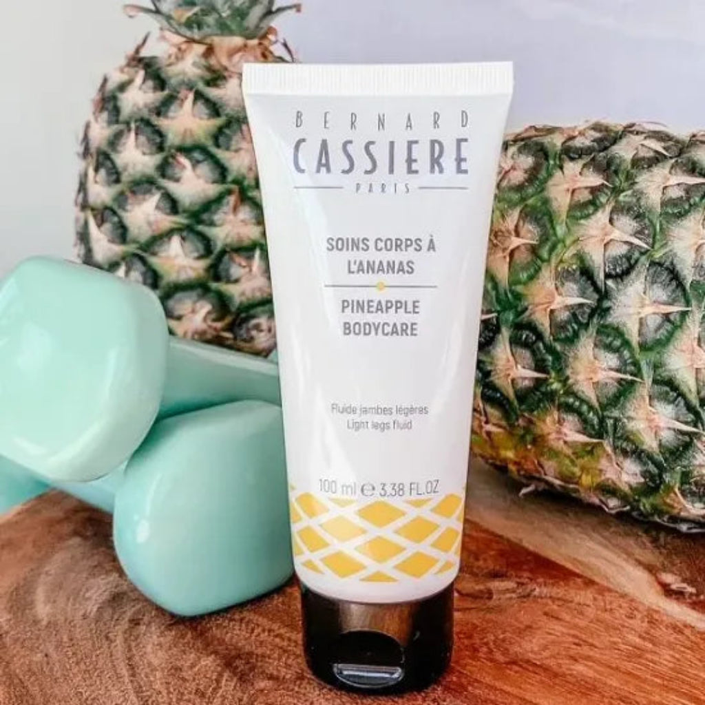 Squeeze tube of Bernard Cassiere light legs fluid with weights and fresh pineapples in the background 