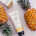 A tube of Bernard Cassiere Paris Pineapple Bodycare slimming gel is displayed diagonally between two whole pineapples on a light pink background, with a branded box partially visible in the top left.
